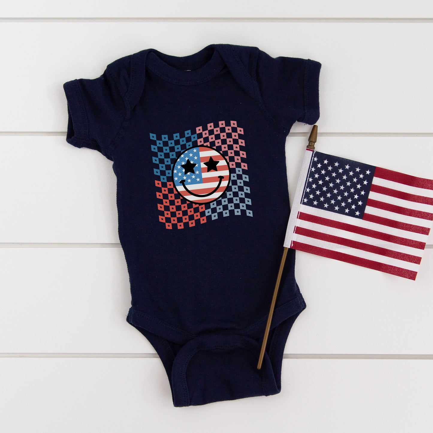 Checkered Patriotic Smiley Face | Baby Graphic Short Sleeve Onesie